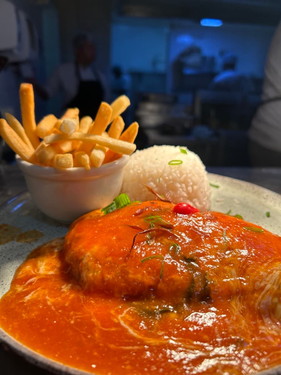 Prato ao molho com arroz e fritas servido no Zin Bar